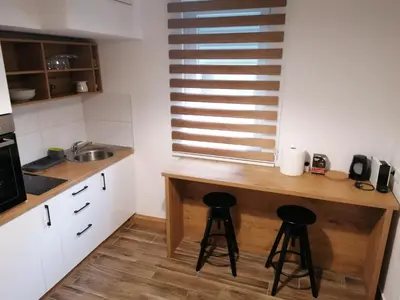 a kitchen with a wooden counter and two stools at Belgrade apartment Bulevar II in Belgrade