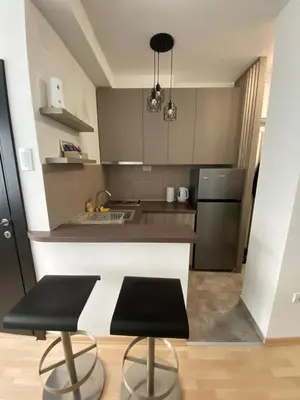 a kitchen with two black chairs and a counter top at Vist 1 apartment in Tošin Bunar