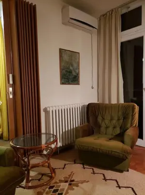 a living room with a chair and a glass table at Idealna lokacija. in Sajmište