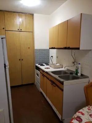 a kitchen with a sink and a stove and cabinets at Idealna lokacija. in Sajmište