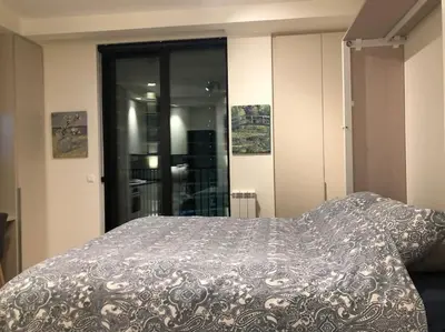 a bedroom with a bed with a blanket on it at Lovely BW Metropolitan studio in Belgrade