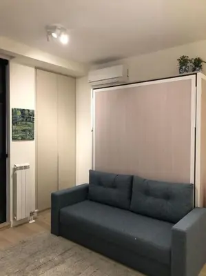 a living room with a blue couch in a room at Lovely BW Metropolitan studio in Belgrade