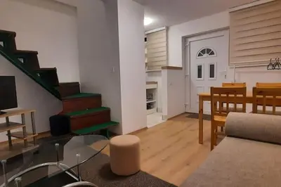 a living room with a glass table and a staircase at Old Cherry Apartment in Vračar (historical)