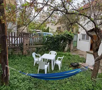 a blue hammock in a yard with a table and chairs at Old Cherry Apartment in Vračar (historical)