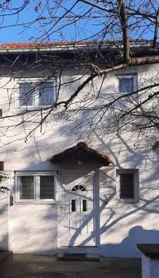 a white house with a white garage at Old Cherry Apartment in Vračar (historical)