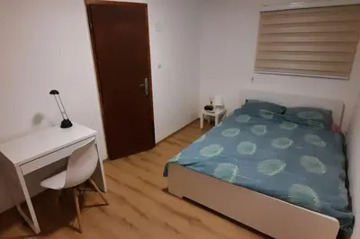 a bedroom with a bed and a desk and a computer at Old Cherry Apartment in Vračar (historical)