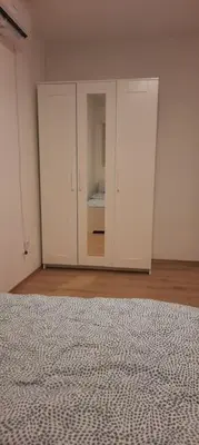 a bedroom with white cabinets and a bed at Old Cherry Apartment in Vračar (historical)