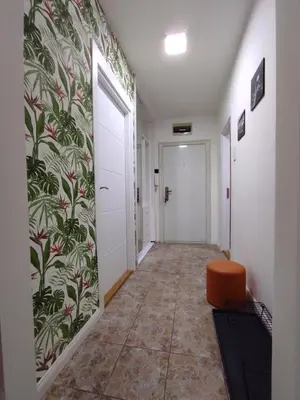 a corridor of a hallway with a door and a chair at GREY apartment in Belgrade