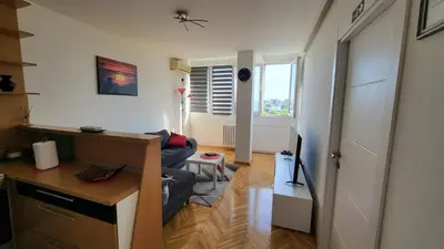 a living room with a couch and a table in it at GREY apartment in Belgrade