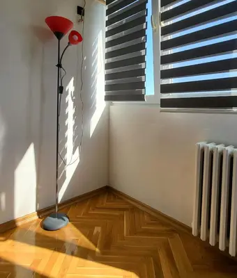 a room with a floor lamp and a window at GREY apartment in Belgrade