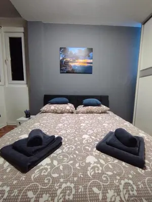 a bedroom with a bed with two pillows on it at GREY apartment in Belgrade