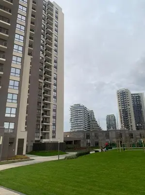 two tall buildings in a city with a grass field at PARK APARTMENTS Belgrade Waterfront in Sajmište