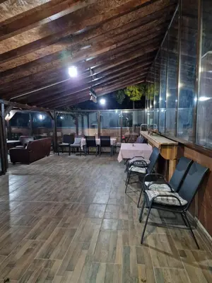 a dining room with tables and chairs and a wooden ceiling at Vila Odiseas in Belgrade
