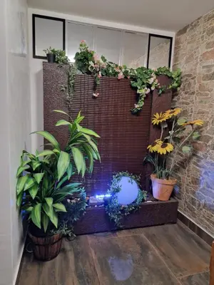 a room with potted plants on a brick wall at Vila Odiseas in Belgrade