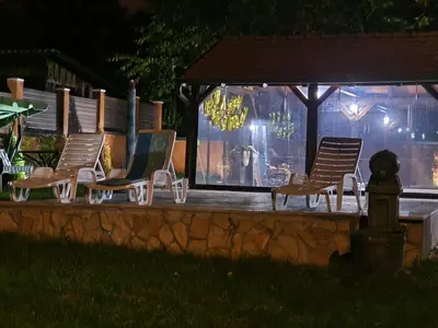 a group of chairs and a gazebo at night at Vila Odiseas in Belgrade