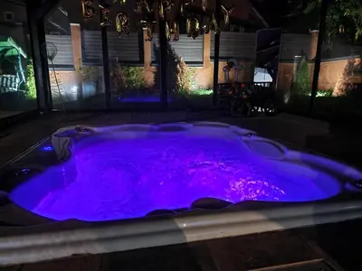 a hot tub lit up purple at night at Vila Odiseas in Belgrade