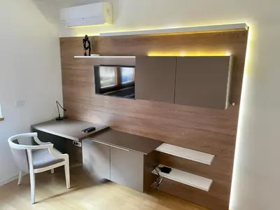 a desk and a chair in a room with a wall at Apartment Maximus II lux in Novi Beograd