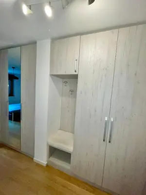 a room with white cabinets and a room with a bed at Apartment Maximus II lux in Novi Beograd