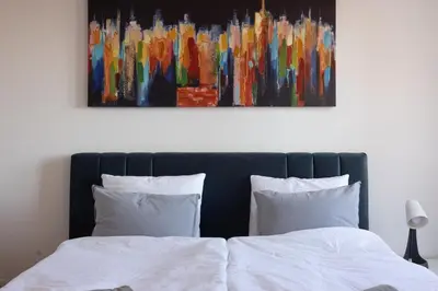 a bedroom with a bed with a painting on the wall at Altina Connect - all new, parking, Netflix in Belgrade
