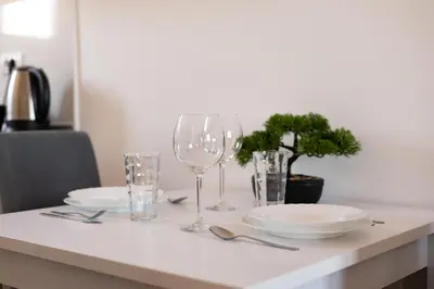 a table with plates and wine glasses on it at Altina Connect - all new, parking, Netflix in Belgrade