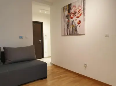 a living room with a couch and a painting on the wall at Altina Connect - all new, parking, Netflix in Belgrade