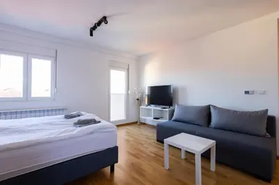 a bedroom with a bed and a couch at Altina Connect - all new, parking, Netflix in Belgrade