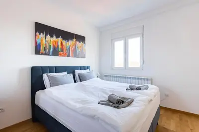 a bedroom with a large white bed with two towels on it at Altina Connect - all new, parking, Netflix in Belgrade