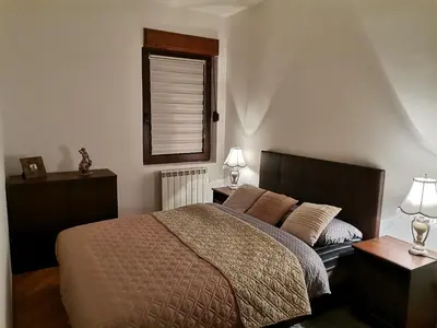 a bedroom with a bed with two lamps and a window at Rajana , Beograd - Hram Svetog Save in Vračar (historical)