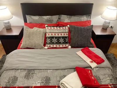 a bed with red and gray pillows and two lamps at Rajana , Beograd - Hram Svetog Save in Vračar (historical)