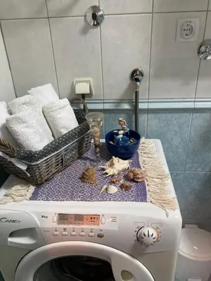 a washing machine in a bathroom with a basket of towels at Rajana , Beograd - Hram Svetog Save in Vračar (historical)
