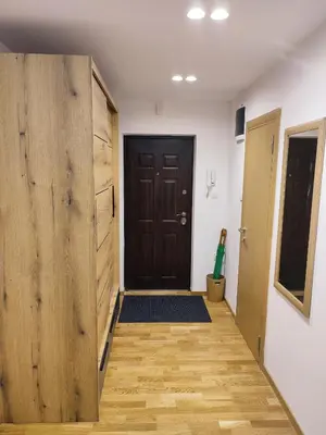a hallway with a wooden door and a wooden floor at TiD Apartman LUX in Arandjelovac