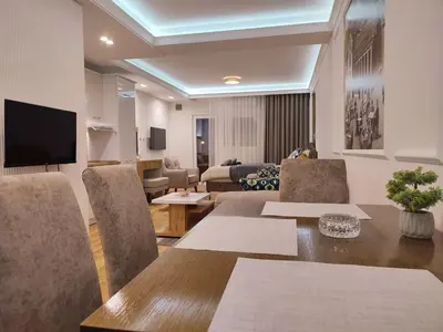 a living room with a table and chairs and a couch at TiD Apartman LUX in Arandjelovac