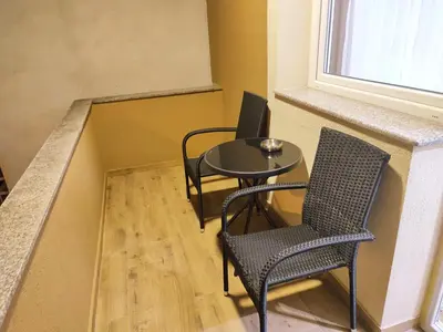 a room with two chairs and a table and a window at TiD Apartman LUX in Arandjelovac