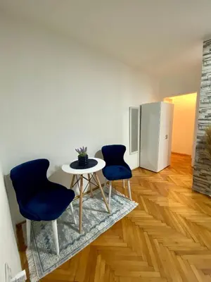 a room with two chairs and a table and a refrigerator at Apartman Espo in Vračar (historical)
