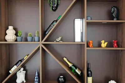 a wall with wooden shelves with bottles of wine at Apartment Paradise Resavska in Belgrade