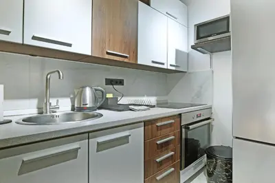 a kitchen with white cabinets and a sink at Apartment Paradise Resavska in Belgrade