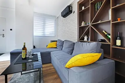 a living room with a blue couch and yellow pillows at Apartment Paradise Resavska in Belgrade