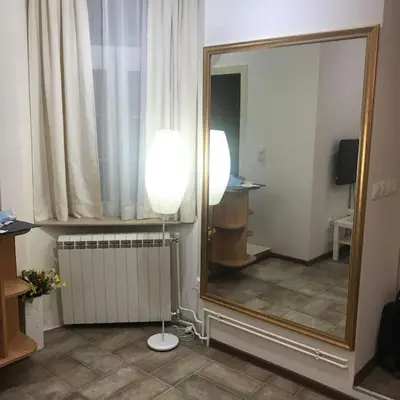 a mirror and a lamp in a room with a mirror at Saint Sava studio in Belgrade