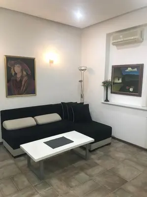a living room with a black couch and a table at Saint Sava studio in Belgrade
