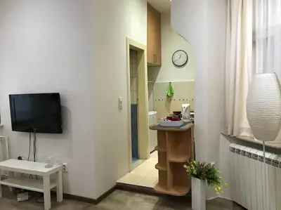 a living room with a clock on a wall at Saint Sava studio in Belgrade