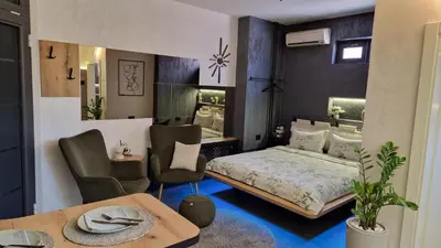 a bedroom with a bed and a table and chairs at Biblioteka Spa Suite in Novi Beograd