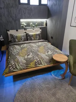 a bedroom with a bed with a table and a couch at Biblioteka Spa Suite in Novi Beograd