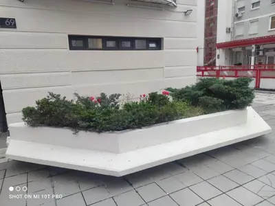 a white bench with plants in it next to a building at Biblioteka Spa Suite in Novi Beograd