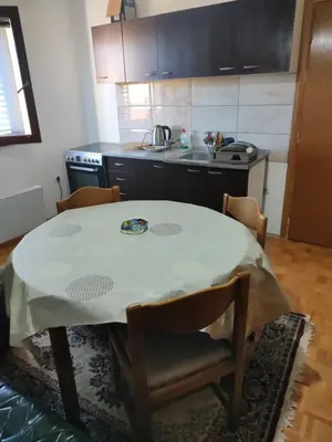 a kitchen with a table with chairs and a sink at Vojin Meljak in Meljak