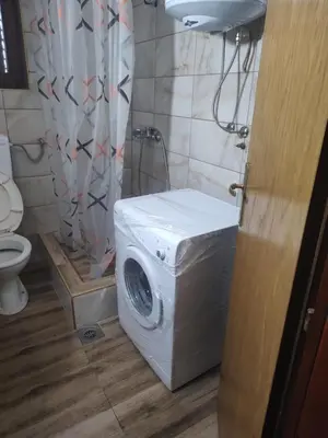 a washing machine in a bathroom with a toilet at Vojin Meljak in Meljak