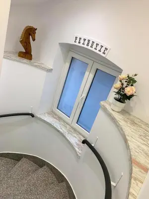 a room with a staircase and a window with flowers at Royal Underground Belgrade in Belgrade