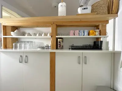 a kitchen with white cabinets and wooden shelves at Royal Underground Belgrade in Belgrade