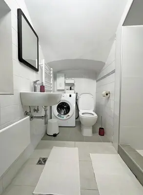 a bathroom with a toilet and a sink and a washing machine at Royal Underground Belgrade in Belgrade