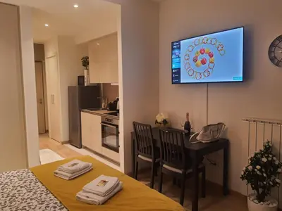 a kitchen with a table and a television on the wall at Belgrade Waterfront Lux Apartment in Belgrade