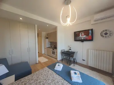 a living room with a blue couch and a clock on the wall at Belgrade Waterfront Lux Apartment in Belgrade